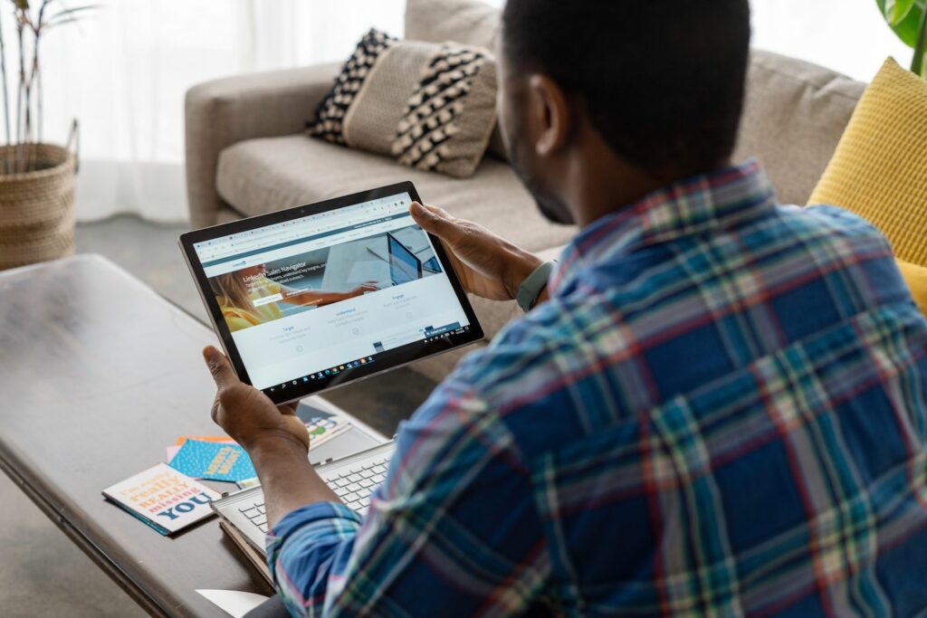 man looking at Linkedin on tablet